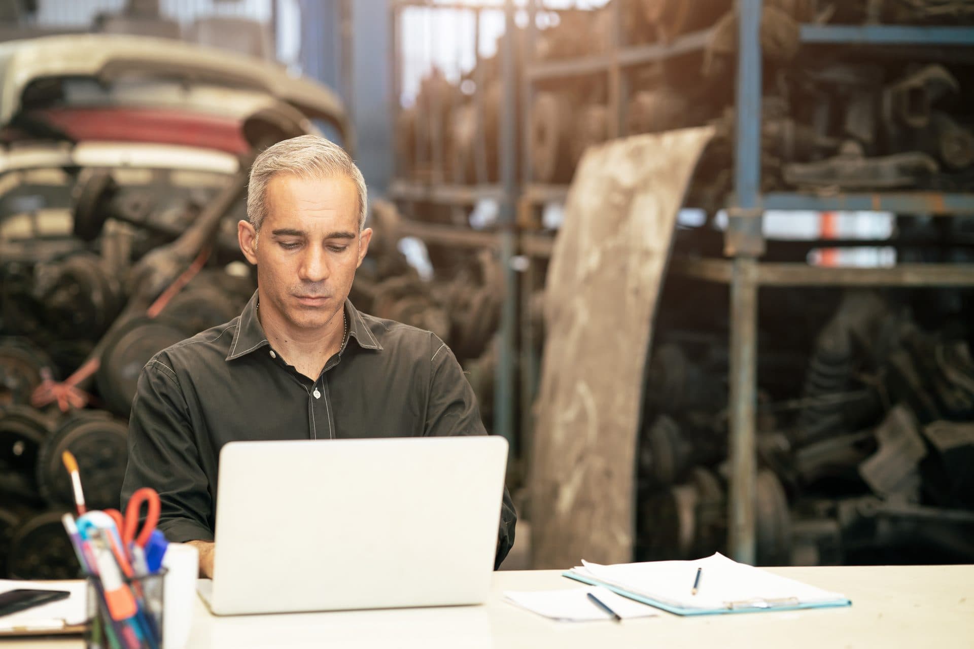 Gérant de garage établissant une facture sur ordinateur au bureau de l'atelier