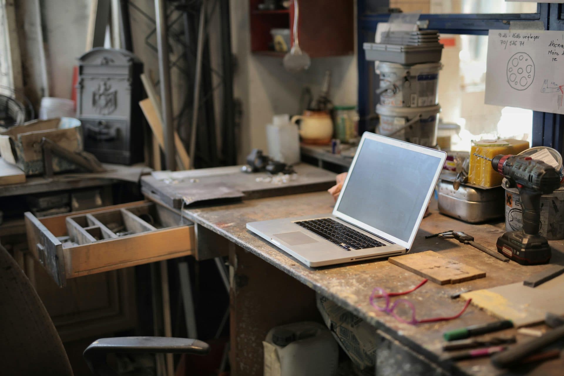 Ordinateur portable posé sur l'établi d'un atelier de garage